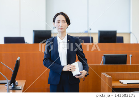法廷で法律書を持つ落ち着いた雰囲気の女性弁護士 143602175