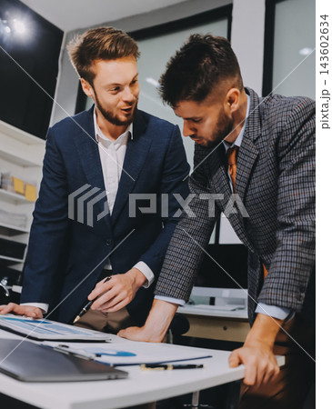 Business team collaborating on digital data analysis in modern office Business team collaborating on digital data analysis in modern office 143602634