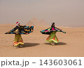 Two Egyptian sufi whirling dervish performers spinning vibrant colorful robes at the Great Pyramids of Giza in Egypt ideal for travel tourism and MENA 143603061
