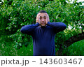 Middle aged man holding head with both hands and reacting to stress fear or unexpected situation outdoors 143603467