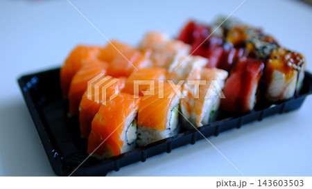 Delicious sushi delivery in black containers with assorted fresh rolls on white background Delicious sushi delivery in black containers with assorted fresh rolls on white background 143603503