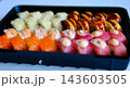 Sushi set with shrimp salmon tuna cream cheese and sesame in black takeaway container delivery food close up video presentation  143603505