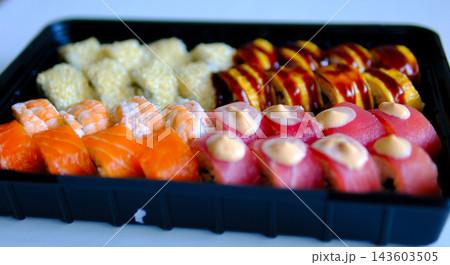 Sushi set with shrimp salmon tuna cream cheese and sesame in black takeaway container delivery food close up video presentation  143603505