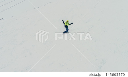 Snowboarder in neon jacket riding steep snowy mountain slope with arms raised for balance Snowboarder in neon jacket riding steep snowy mountain slope with arms raised for balance 143603570