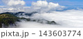 Mountain ridges emerging through thick white clouds under a blue sky creating a dramatic high-altitude natural landscape, Madeira, Portugal. 143603774