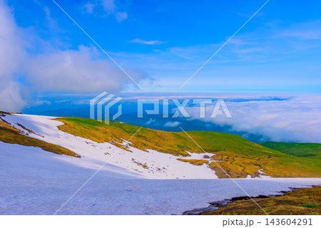 夏の月山山頂から眼下に広がる広大な雪渓と遠く連なる美しく壮大な雲海を捉えたパノラマ風 夏の月山山頂から眼下に広がる広大な雪渓と遠く連なる美しく壮大な雲海を捉えたパノラマ風 143604291