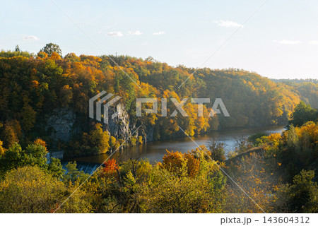 Autumn Forest Reflected Across Quiet Lake. Peaceful autumn nature concept symbolizing seasonal transformation harmony and beauty of untouched landscapes Autumn Forest Reflected Across Quiet Lake. Peaceful autumn nature concept symbolizing seasonal transformation harmony and beauty of untouched landscapes 143604312