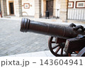 Ancient iron cannon on wooden wheels in a castle courtyard 143604941