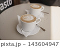 Two cups of hot cappuccino with latte art on a table in a cafe 143604947