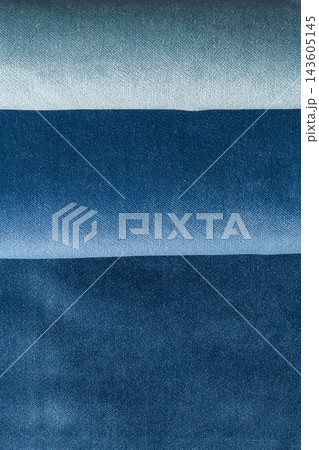 Shades of blue folded denim fabric texture concept Shades of blue folded denim fabric texture concept 143605145
