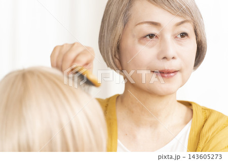薄毛に悩みウイッグをつけるシニア女性 薄毛に悩みウイッグをつけるシニア女性 143605273