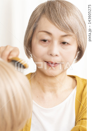 薄毛に悩みウイッグをつけるシニア女性 143605275