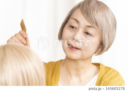 薄毛に悩みウイッグをつけるシニア女性 薄毛に悩みウイッグをつけるシニア女性 143605278