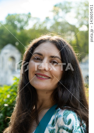 Close up headshot of beautiful middle aged brunette woman looking at camera Close up headshot of beautiful middle aged brunette woman looking at camera 143605451
