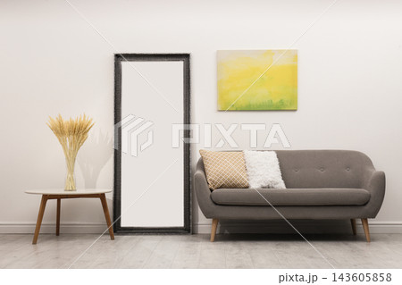 Large mirror and comfortable sofa in living room 143605858