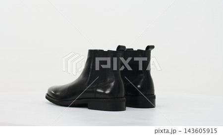Pair of men's black leather chelsea boots showcasing fashion and elegance, ready for casual or formal wear Pair of men's black leather chelsea boots showcasing fashion and elegance, ready for casual or formal wear 143605915