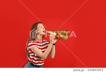 Young woman with megaphone on red background Young woman with megaphone on red background 143607951