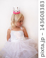 Little Blonde Girl Wearing Princess Crown and Dress Looking Down  143608383