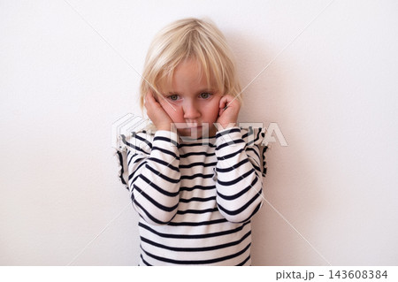 Naughty Little Blonde Girl Covering Ears and Making a Face 143608384