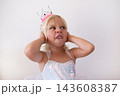 Disgusted Little Blonde Girl Wearing Princess Crown and Dress Pinching Nose  143608387