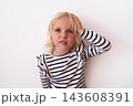 Frustrated Little Blonde Girl Holding Hand on Head and Grimacing  143608391