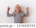 Relaxed Little Blonde Girl Meditating with Calm Expression on White Background 143608393