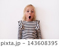 Surprised Little Blonde Girl with Wide Eyes and Open Mouth on White Background 143608395