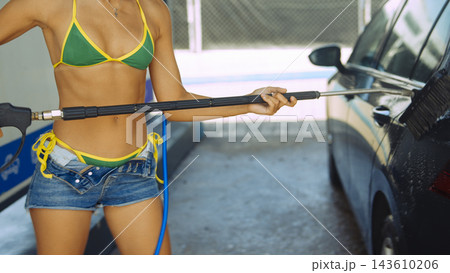 Woman washing a car with pressure washer outdoors Woman washing a car with pressure washer outdoors 143610206