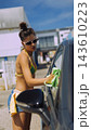 Young woman washing a car outdoors in summer sunshine 143610223