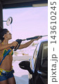 Woman washing car with pressure washer at car wash 143610245