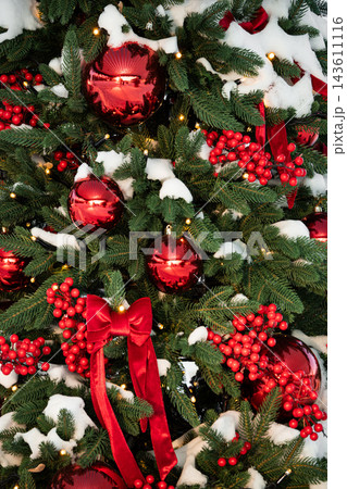 Christmas tree decorated with red baubles and snow Christmas tree decorated with red baubles and snow 143611116