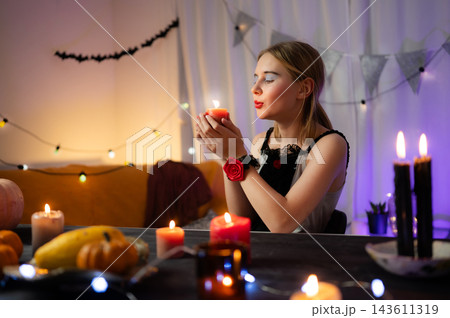 Cute Little Girl Playing In A Festive Decorated Room For Halloween Blows Out A Candle Cute Little Girl Playing In A Festive Decorated Room For Halloween Blows Out A Candle 143611319
