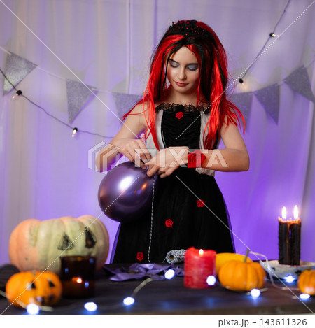 Cute Little Girl In A Halloween Witch Wig Blows Up A Balloon While Decorating A Holiday Room Cute Little Girl In A Halloween Witch Wig Blows Up A Balloon While Decorating A Holiday Room 143611326