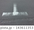アスファルト路面に描かれたT字交差点の白線標示とひび割れ 143611353