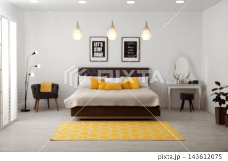 Blurred view of stylish room interior with comfortable bed 143612075