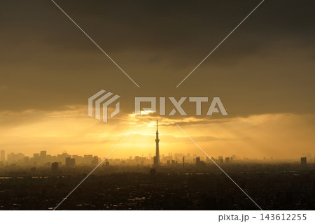 秋の不安定な天気 夕焼け空の厚い雲から差し込む天使の梯子(薄明光線・光芒)と東京の都市風景 秋の不安定な天気 夕焼け空の厚い雲から差し込む天使の梯子(薄明光線・光芒)と東京の都市風景 143612255