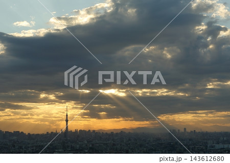 秋の不安定な夕方の空模様 暗い雲と天使の梯子（薄明光線・光芒）東京の都市風景 143612680