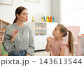 Speech therapist working with little girl in office 143613544
