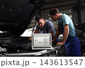 Laptop with vehicle tracking system and blurred mechanics on background. Auto diagnostic 143613547