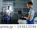 Mechanic with laptop doing car diagnostic at automobile repair shop. Space for text 143613548