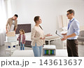 Salesman consulting young woman in mattress store 143613637