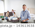 Happy salesman and his clients in mattress store 143613638