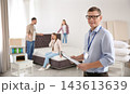 Happy salesman and his clients in mattress store 143613639