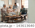Young woman taking care of elderly people in living room 143613640