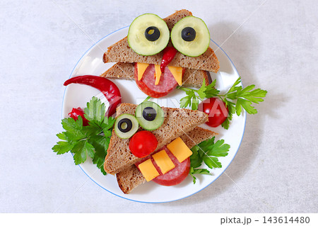 Fun dishes for children and food presentation ideas for holidays, birthdays and Halloween. Whimsical faces with fangs and horns, arranged using slices of bread, salami, cucumber, tomato, olives Fun dishes for children and food presentation ideas for holidays, birthdays and Halloween. Whimsical faces with fangs and horns, arranged using slices of bread, salami, cucumber, tomato, olives 143614480