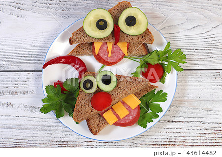 Fun dishes for children and food presentation ideas for holidays, birthdays and Halloween. Whimsical faces with fangs and horns, arranged using slices of bread, salami, cucumber, tomato, olives Fun dishes for children and food presentation ideas for holidays, birthdays and Halloween. Whimsical faces with fangs and horns, arranged using slices of bread, salami, cucumber, tomato, olives 143614482