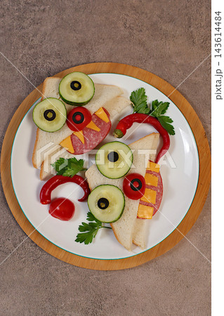Fun dishes for children and food presentation ideas for holidays, birthdays and Halloween. Whimsical faces with fangs and horns, arranged using slices of bread, salami, cucumber, tomato, olives Fun dishes for children and food presentation ideas for holidays, birthdays and Halloween. Whimsical faces with fangs and horns, arranged using slices of bread, salami, cucumber, tomato, olives 143614484