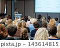 Conference attendee photographing a presentation with a smartphone 143614815