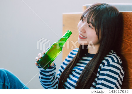 リビングでビールを飲む若い女性 143617083