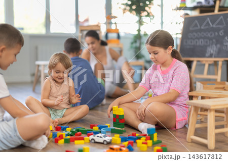 Boy and girl playing on floor with educational toys. Children toddlers at daycare Boy and girl playing on floor with educational toys. Children toddlers at daycare 143617812